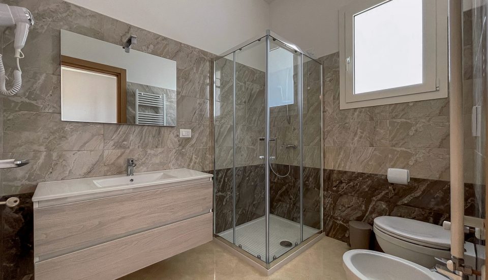 bagno con lavandino e doccia sullo sfondo del Karpignàna Hotel