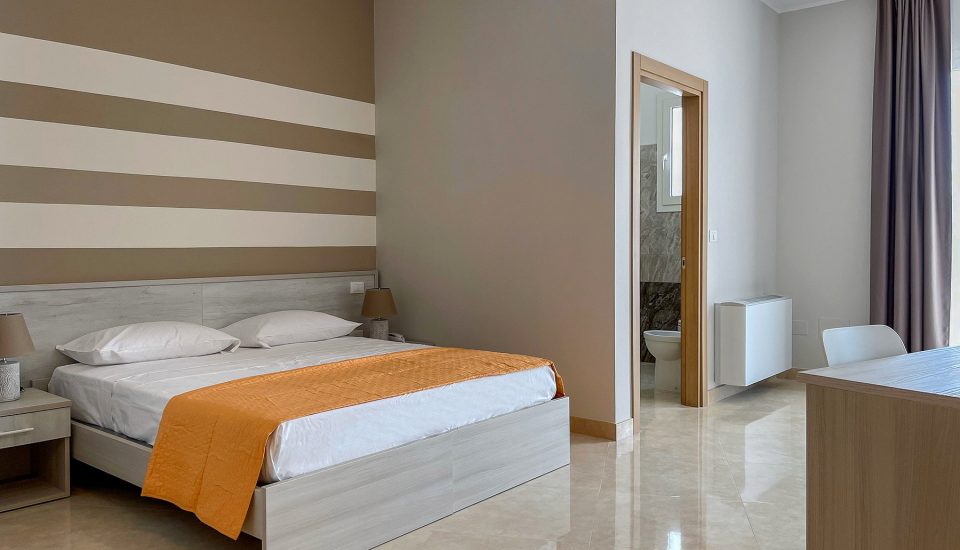 camera con letto e bagno sullo sfondo del Karpignàna Hotel